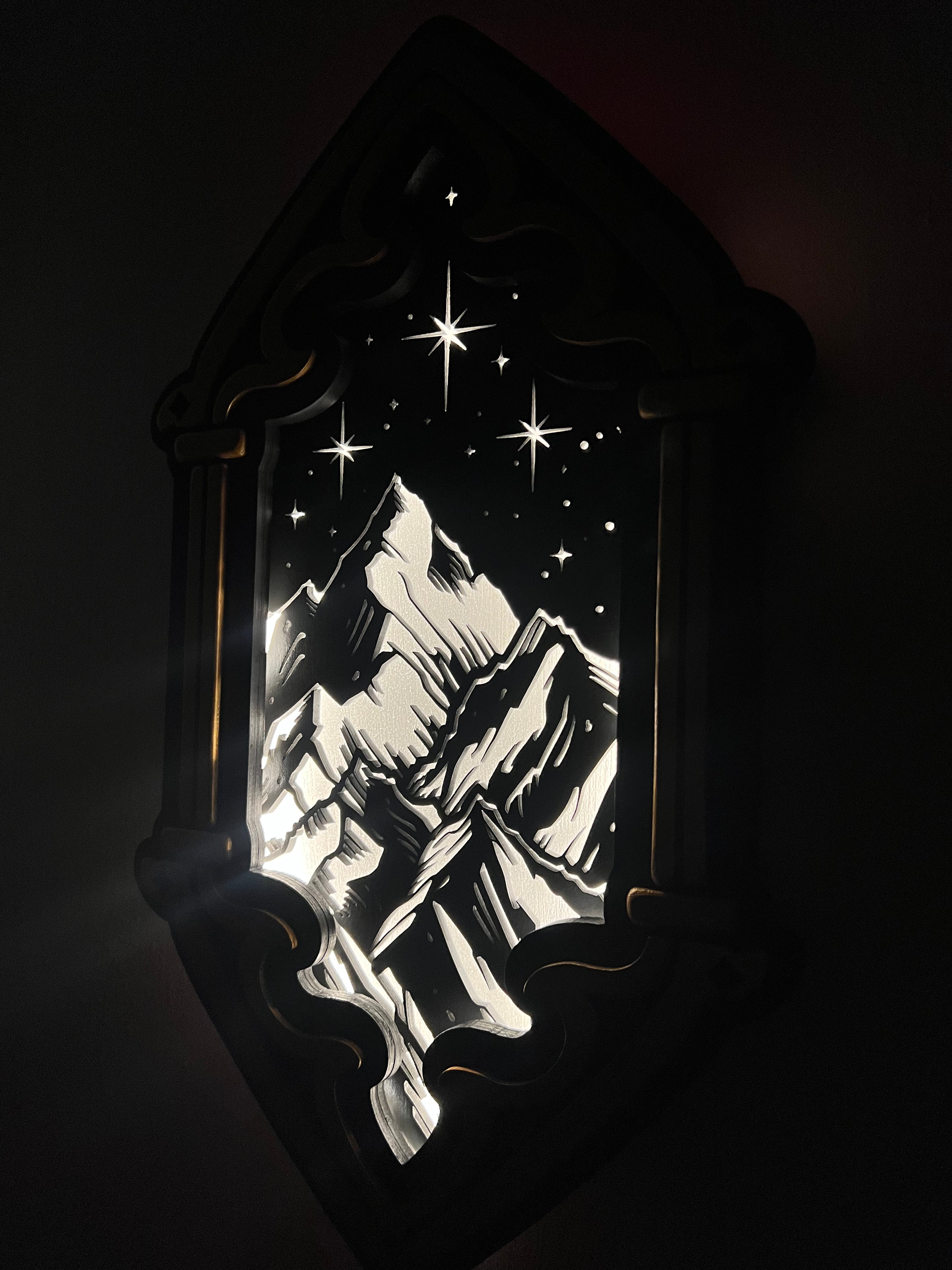 Cadre lumineux Everlore avec cassette montagnes et étoiles allumée dans l'obscurité, sommets enneigés gravés au laser et ciel étoilé lumineux — lampe déco fantasy bookish handmade